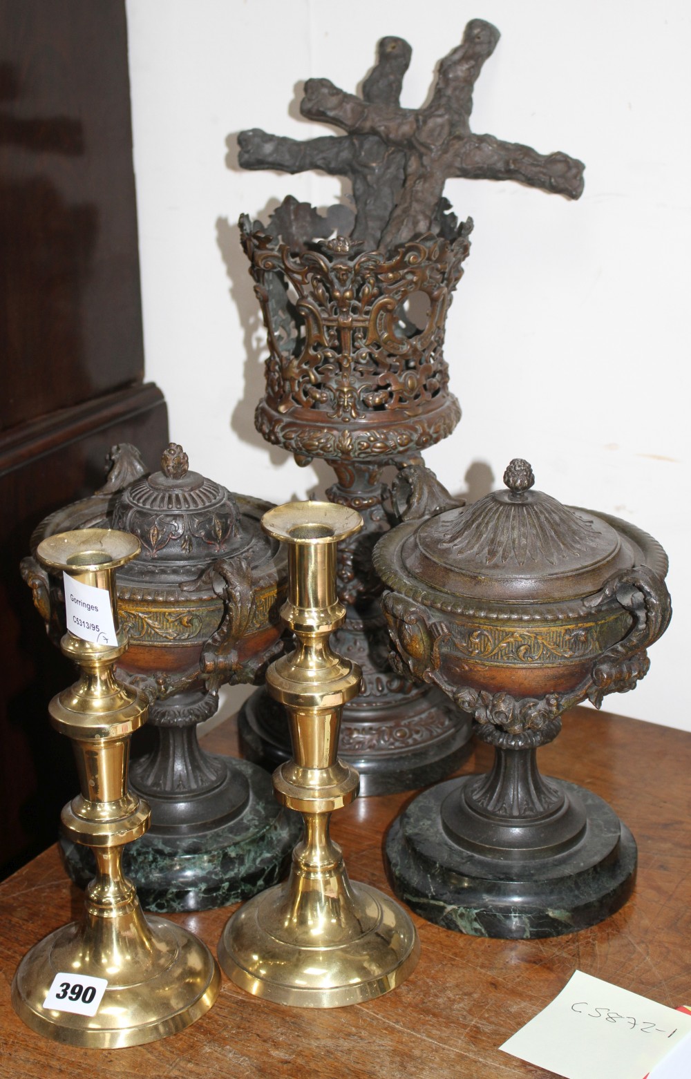 A pair of late Victorian cast iron two handled urns, one with odd lid, an oil lamp base, a pair of cast iron crosses and a pair of bras